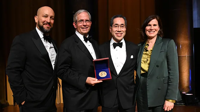 Four people dressed in evening wear. 