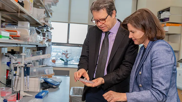 A woman and a man looking at part of an experiment in a medical lab. 