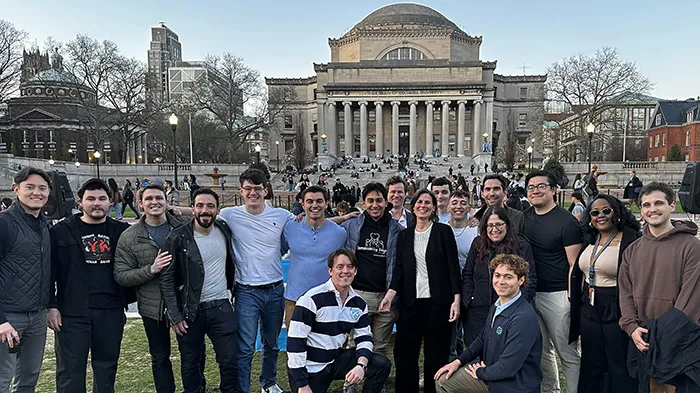 A group of students and Acting President Shipman gathered on the lawn with a view of Low Library in the back. 
