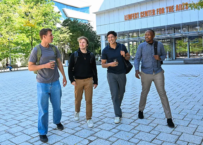 Four students cross the Manhattanville campus.