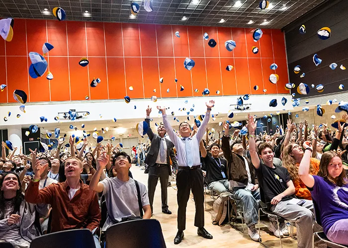 SEAS students throw celebratory beanies into the air.