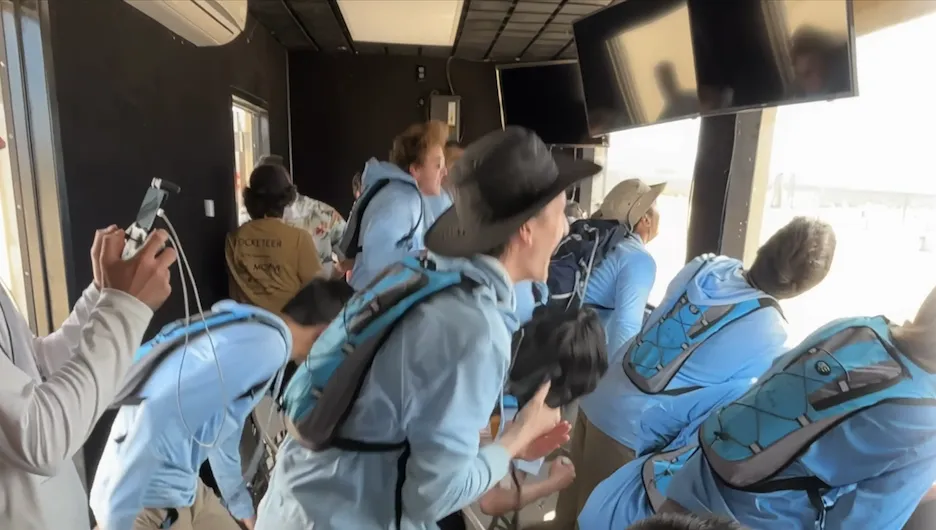 Students in Columbia “blue” shirts watching the launch of a space mission.