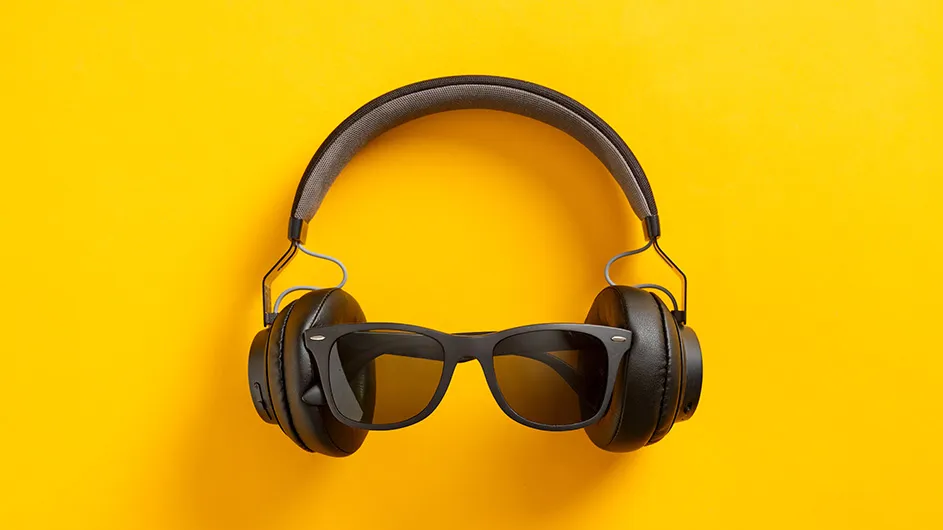 Headphones with sunglasses on a yellow background.
