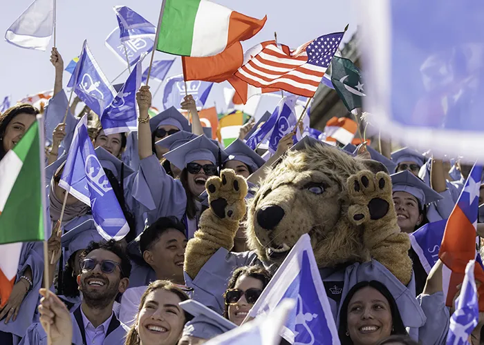 Graduates of the School of International and Public Affairs wave their flags during the morning’s graduate Commencement ceremony. Photo by Lucas Hoeffel/Columbia University.