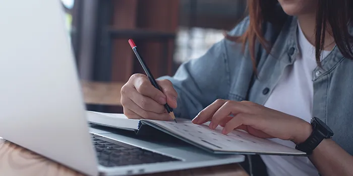 A computer and a planner and a student using both. 