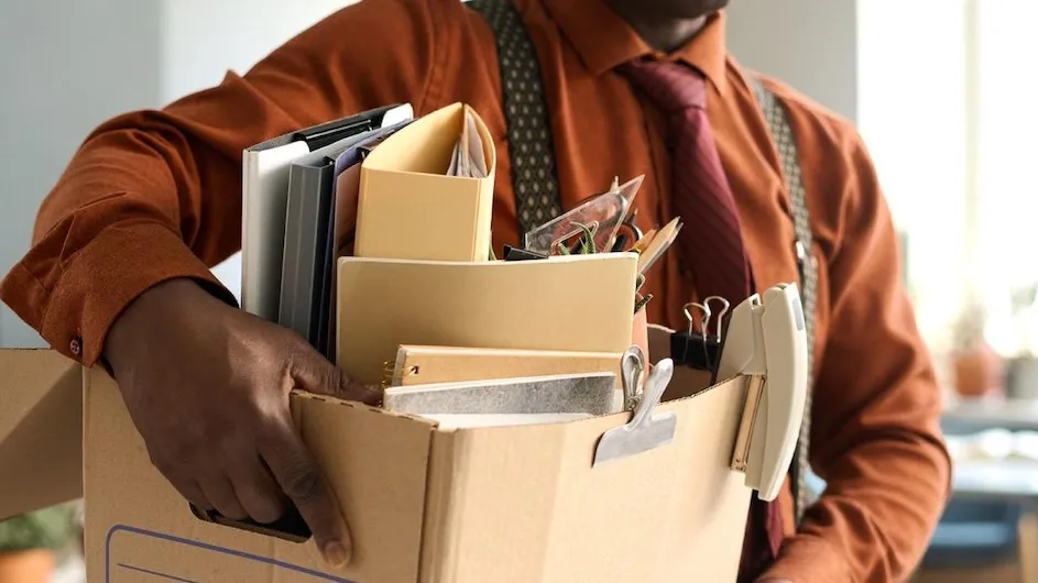 A person carrying a box out of a workplace