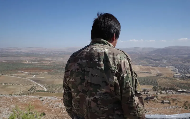 A senior Uyghur militant looking out over an olive grove in northern Syria. Photo by Emily Feng.