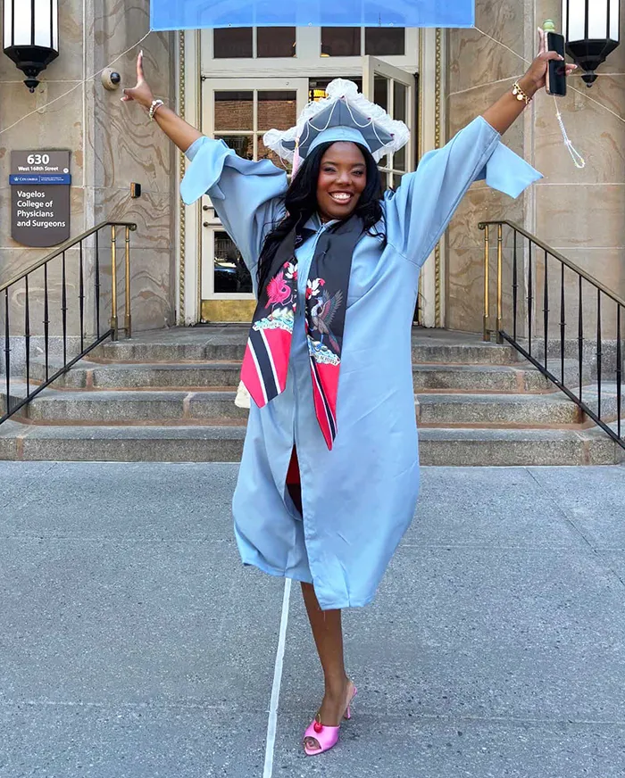 A grad in front of the Vagelos College of Physicians and surgeons. 