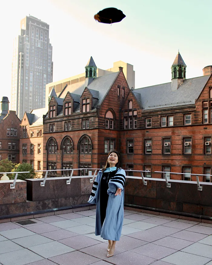 Lynn Dao (TC’25) poses with Teachers college behind her.