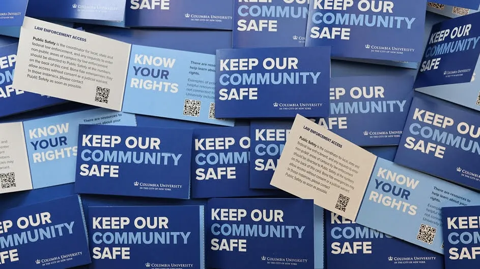 A photo of a pile of Columbia University blue and white palm cards announcing "Keep Our Community Safe" and "Know Your Rights."