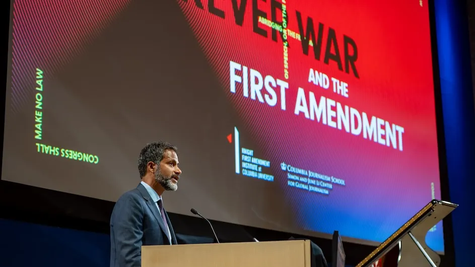 Jameel Jaffer, executive director of the Knight First Amendment Institute, speaks to audience from a podium on a stage at the “Forever War and the First Amendment” symposium at Columbia University. Photo by Siobhan Mullan