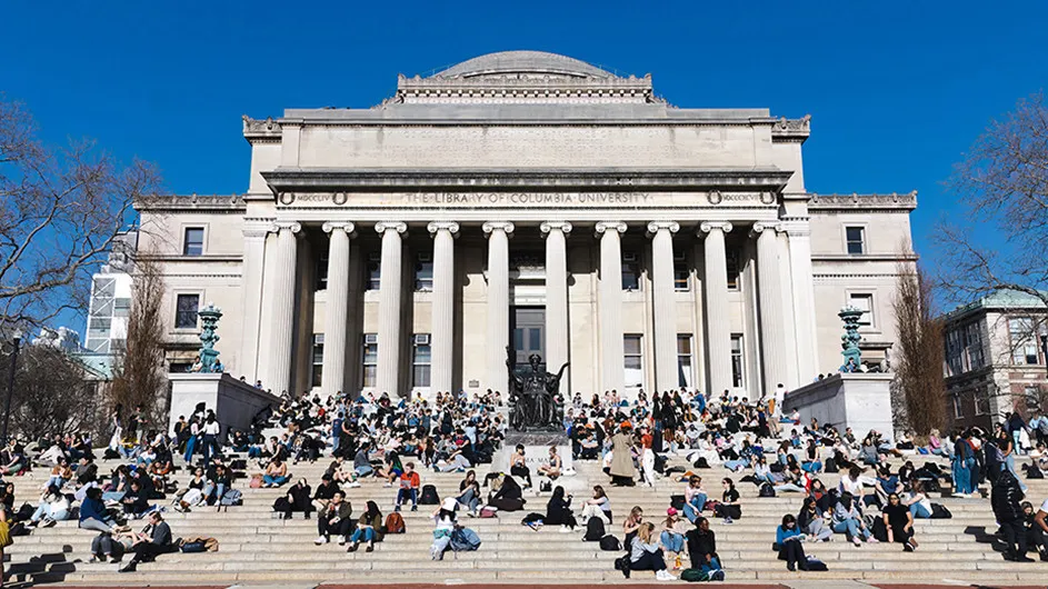 Students sitting on the steps of Low Library on a sunny day