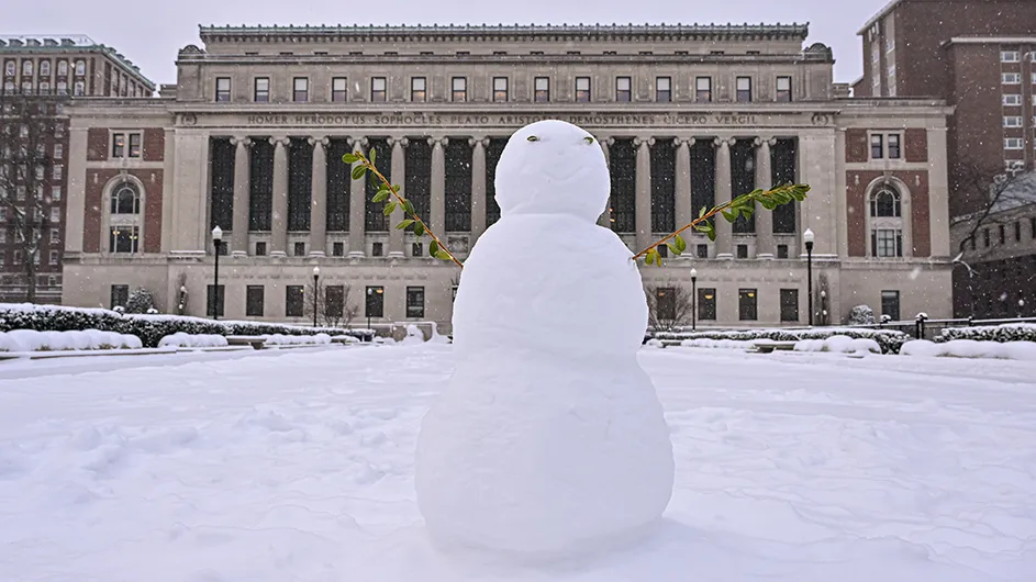 A snowman on snowy South Lawn with Butler Library in the background at Columbia University. 