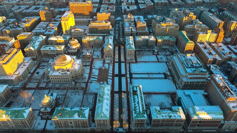 Aerial of Columbia University Morningside campus in snow at sunset.