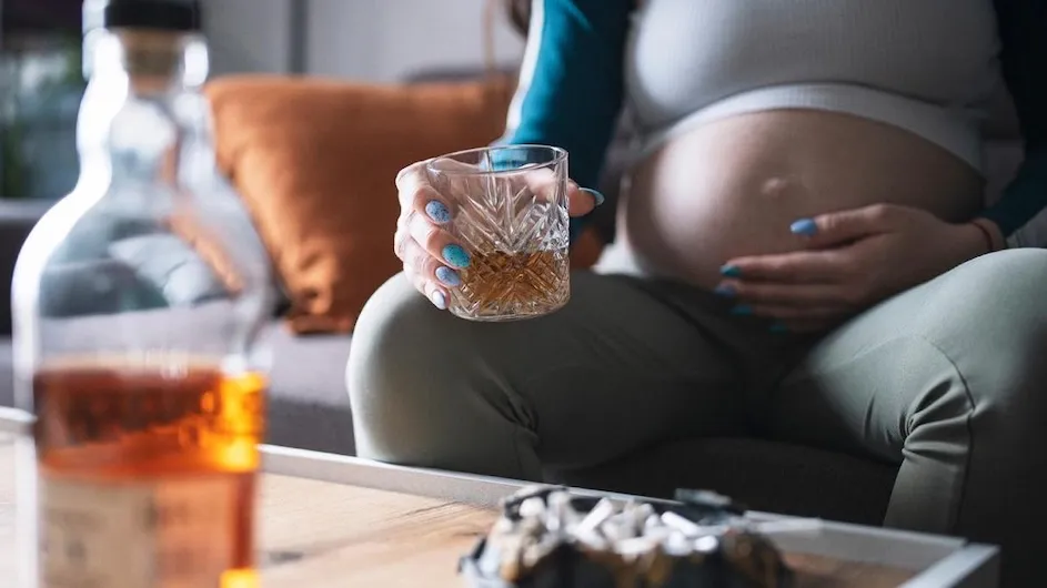 A pregnant person drinking alcohol.