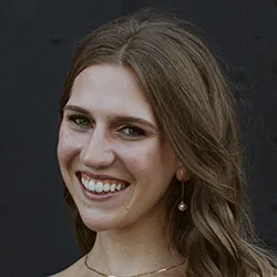 A woman with long brown hair, smiling.