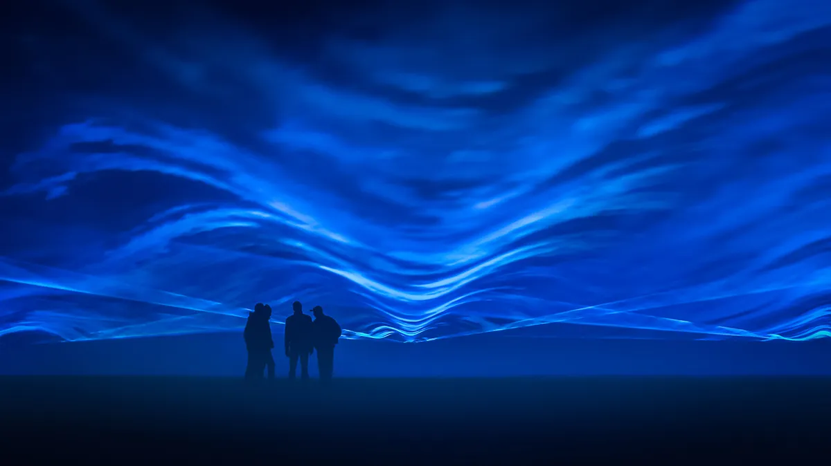 A few men standing in front of waves of blue light