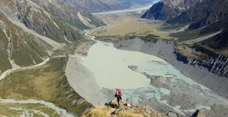 illustration of an aeriel view of mountains while a hiker makes his way up a trail