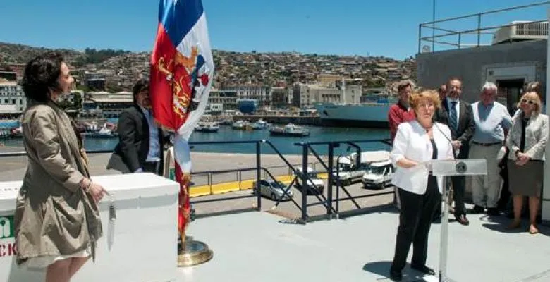 Chilean President Michelle Bachelet stands at outdoor podium speaking to a group 