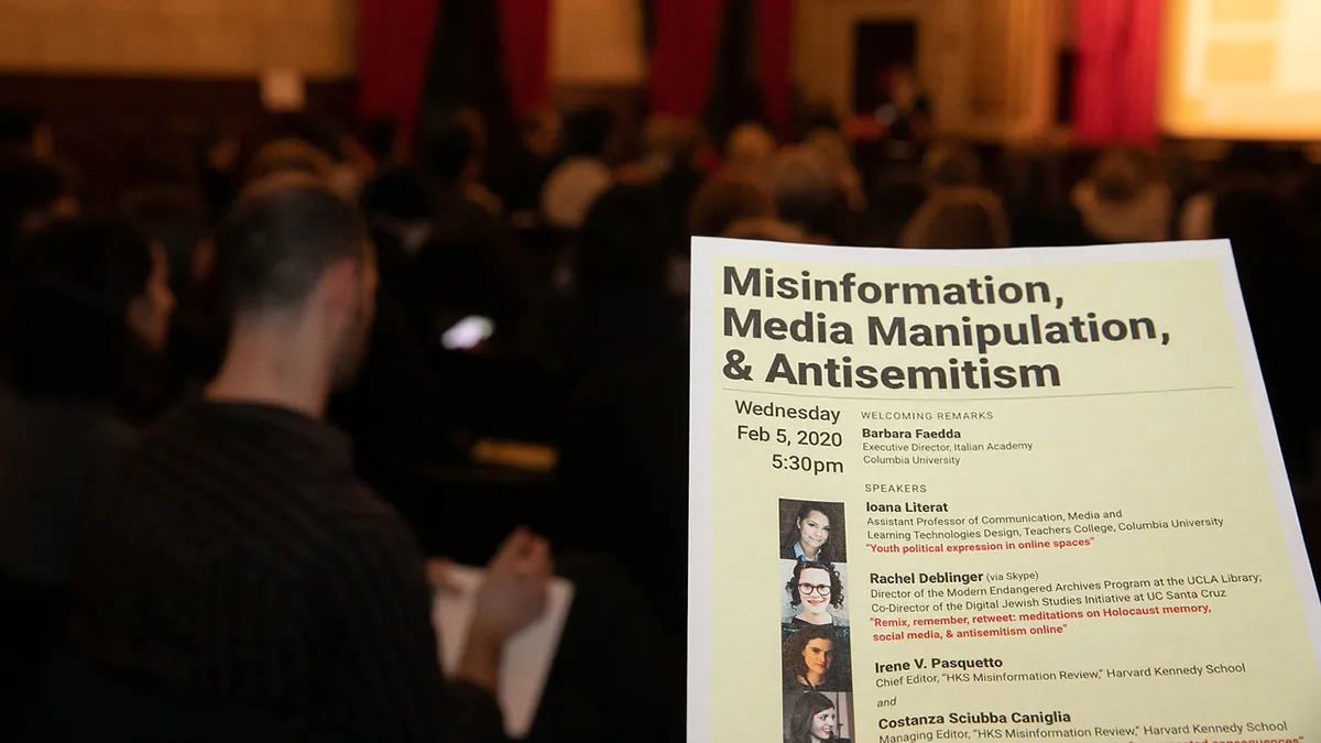 A sheet of paper held up in front of an audience.