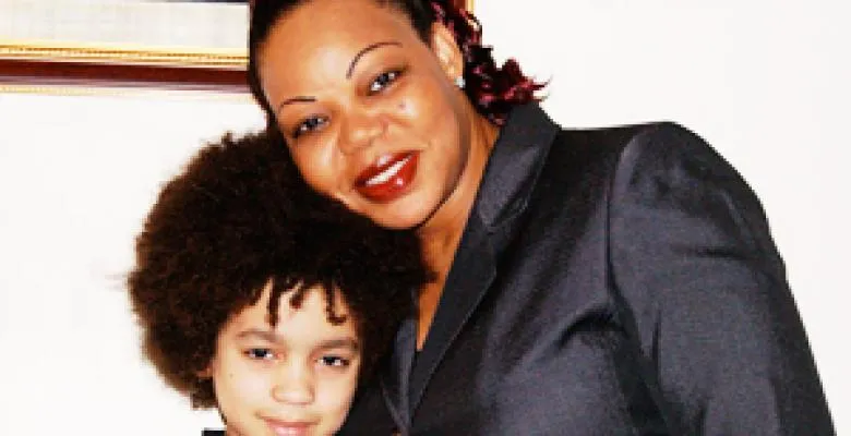 Businesswoman leaning over and hugging a young boy
