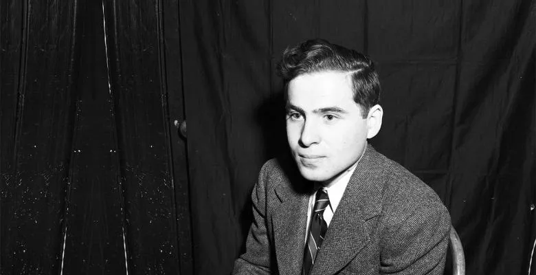 A black-and-white photograph of Arthur Ashkin, taken May 27, 1947. Ashkin wears a suit and tie and looks off into the distance while seated. Photo courtesy Columbia University Archives
