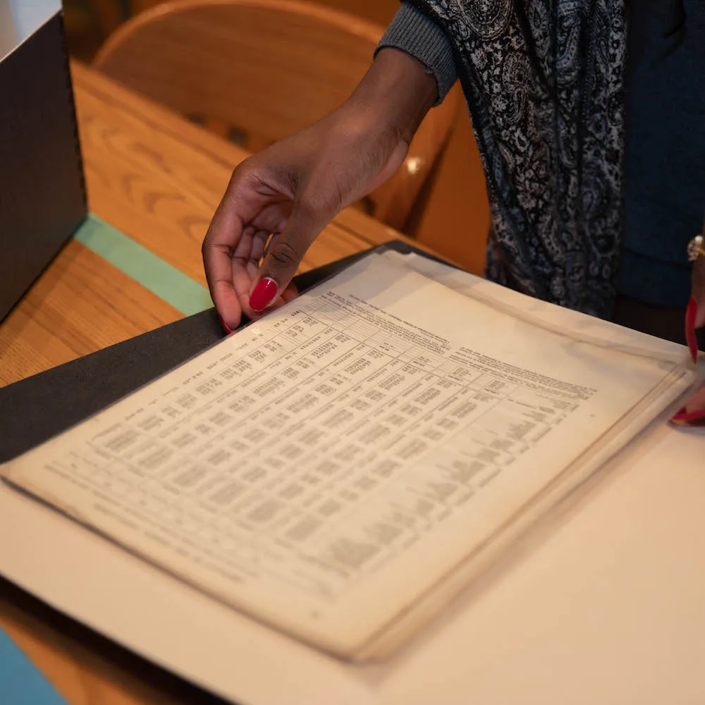 A women with red nails holding an old ledger