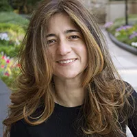 Frances Negrón-Muntaner with flowy hair in a black blouse. 