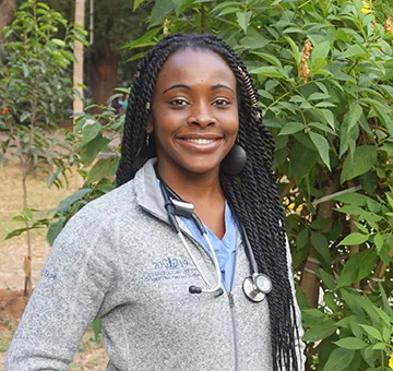 Etoro Ekpe in a gray Columbia sweater and a stethoscope around her neck.