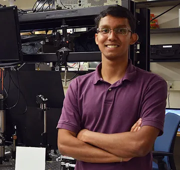 Jyotirmoy Mandal in a red polo standing in front of computer parts.
