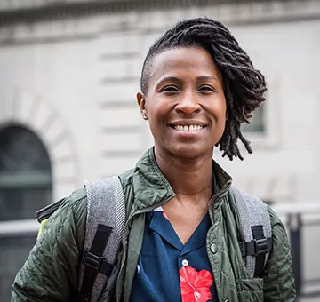 Sondra Woodruff smiling, wearing a dark green jacket and a backpack.