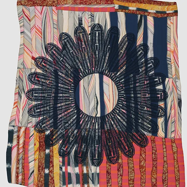 A colorful quilt with a lotus flower stitched into it.