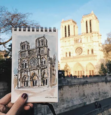 Sketch of Notre Dame being held up in front of the actual Notre Dame building