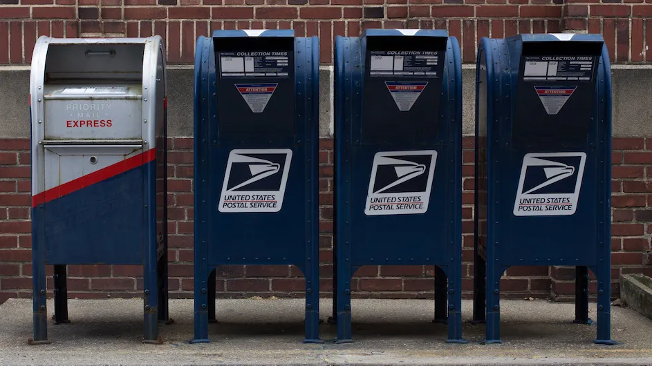 Four post office boxes lined up in a row.