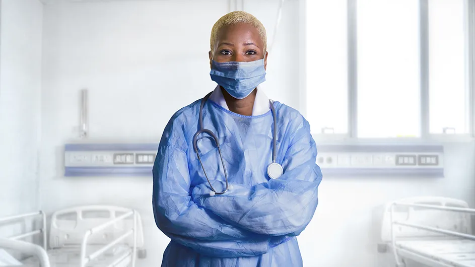 A woman in a face mask and scrubs.