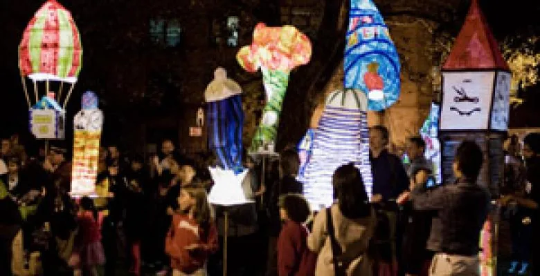 In the darkness, a group of brightly lit lanterns light up the night
