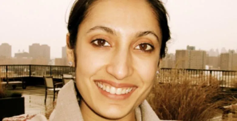 A dark-haired young woman smiles at the camera