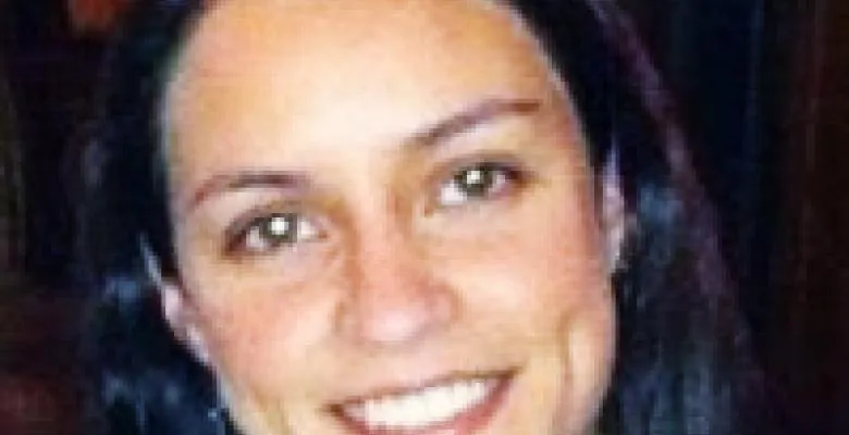 A young dark-haired woman smiles at the camera