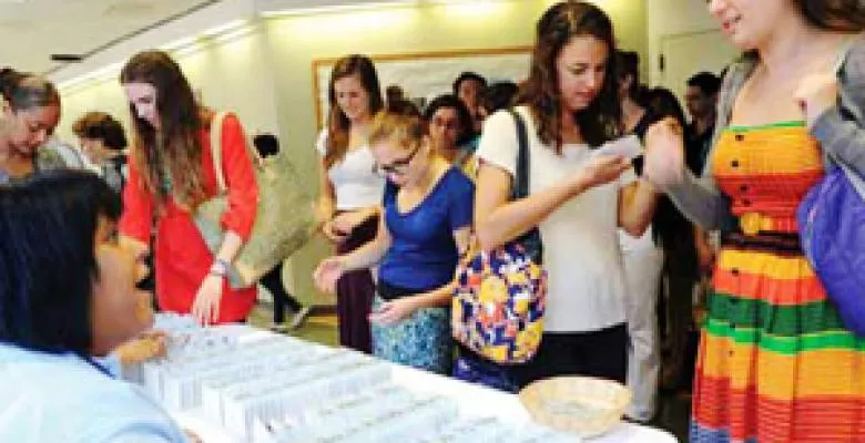 A diverse mix of young students check in at a table