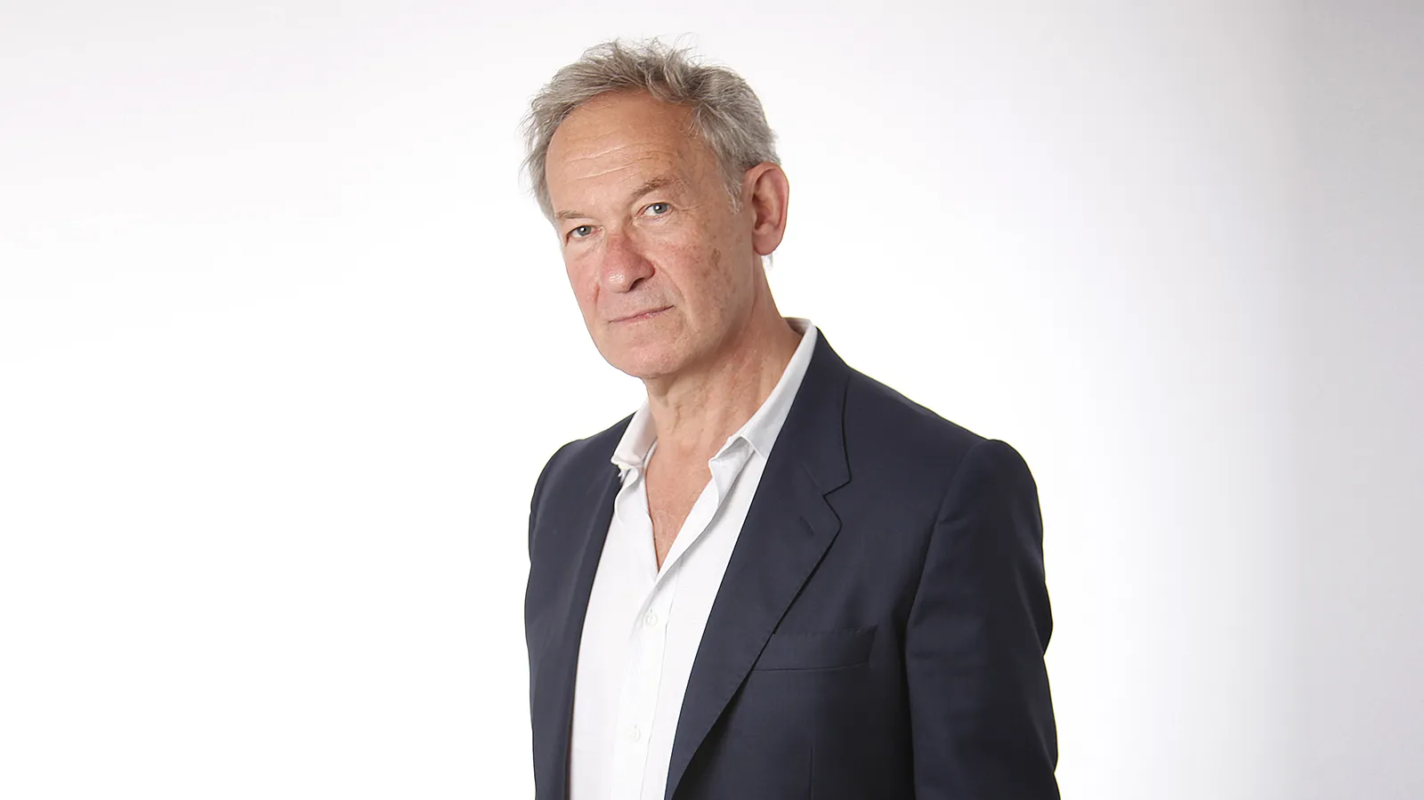 Simon Schama: man with short gray hair, wearing a white shirt and a dark jacket.