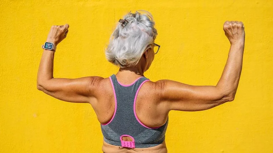 An older woman flexes her arms.
