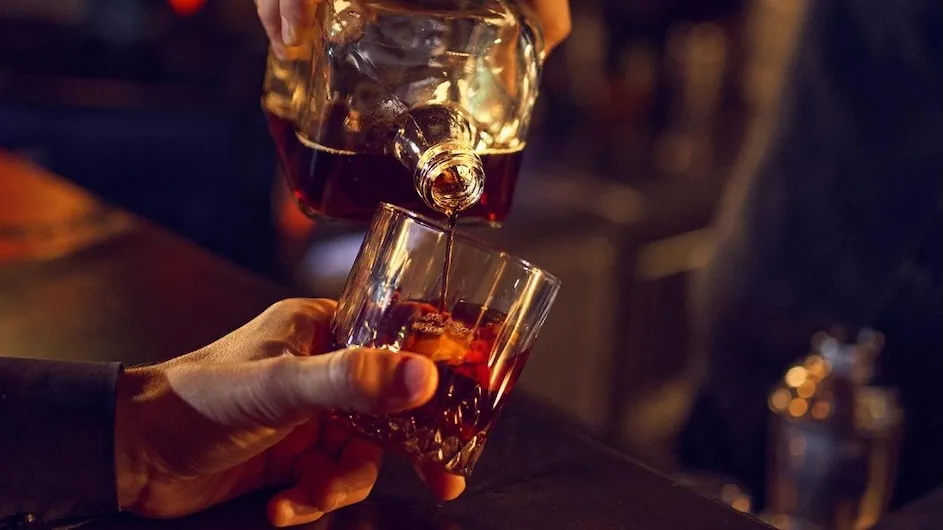A person pouring an alcoholic drink.