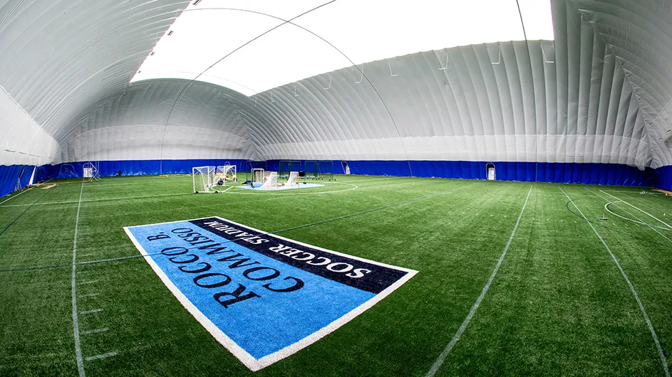 Inside the Bubble at Columbia University’s Baker Athletics Complex: green sports field with goalie nets in the background inside a dome.  