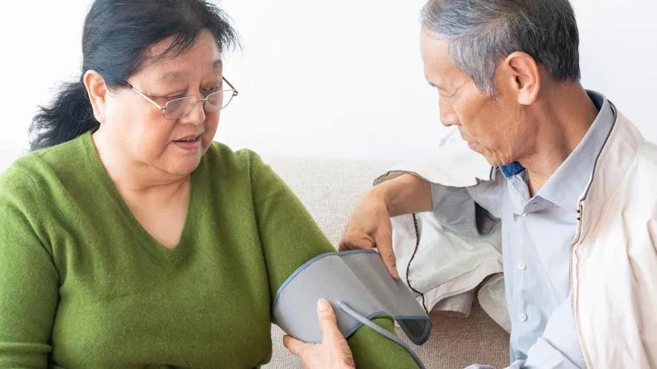 A man measures a woman's blood pressure.