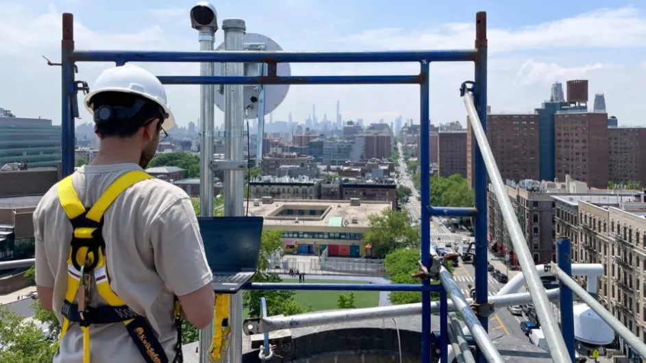 A worker observes New York City from atop scaffolding.