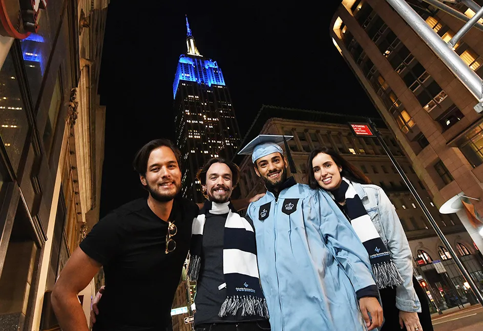 A Columbia grad poses with friends and family at 36th street in front of the Empire State Building. 