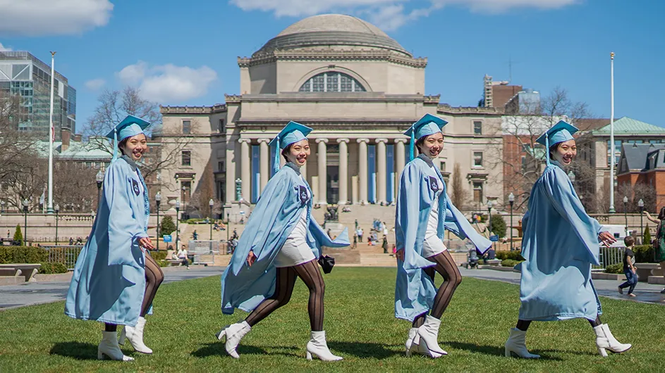 Grad walks in front of low library
