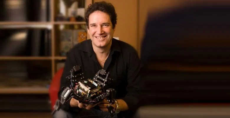 Prof. Lipson holding a hand held robot like machine 