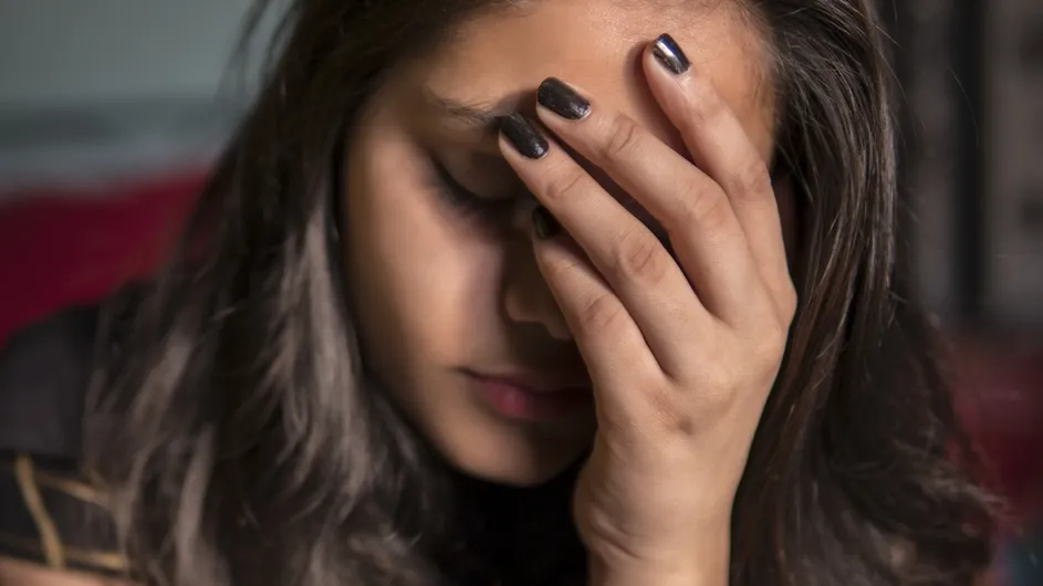A person holding her head in her hands.