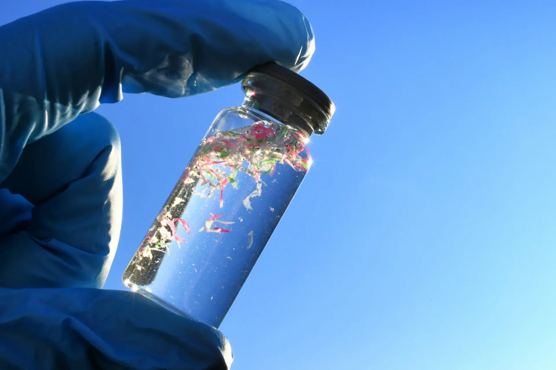 A person holding a vial filled with microplastics